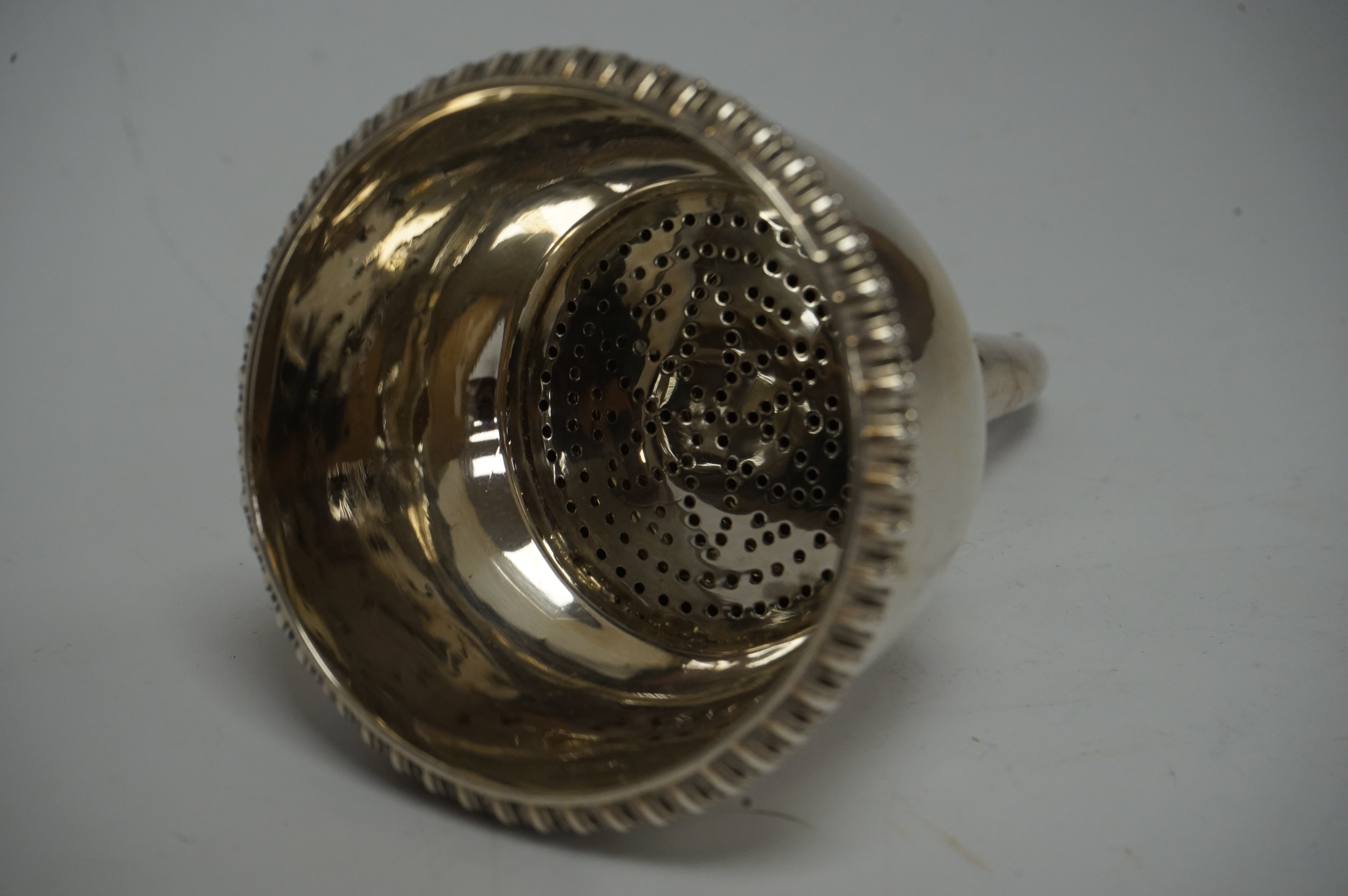 A George III silver wine funnel, by Thomas Johnson, London, 1812, with engraved crest, gadrooned border and shell thumbpiece, no muslin ring, 14.6cm, 5.3oz. Condition - fair to good